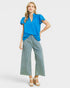 Woman wearing a blue top and striped pants on a white background