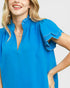 Woman wearing a blue dress with ruffled sleeves on a white background