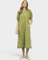 Woman wearing a green dress with white trim on a white background