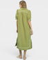 Woman wearing a green dress with white trim on a white background