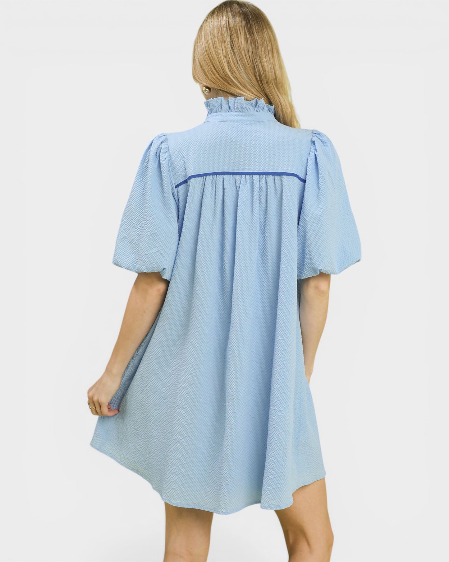 Woman wearing a light blue dress with a white background