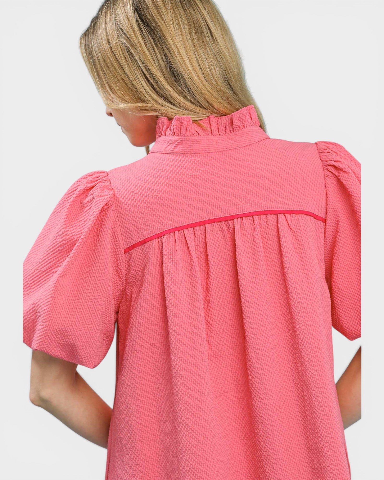 Pink textured blouse with puff sleeves on a white background