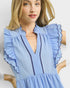 Woman wearing a blue dress with ruffled details on a white background