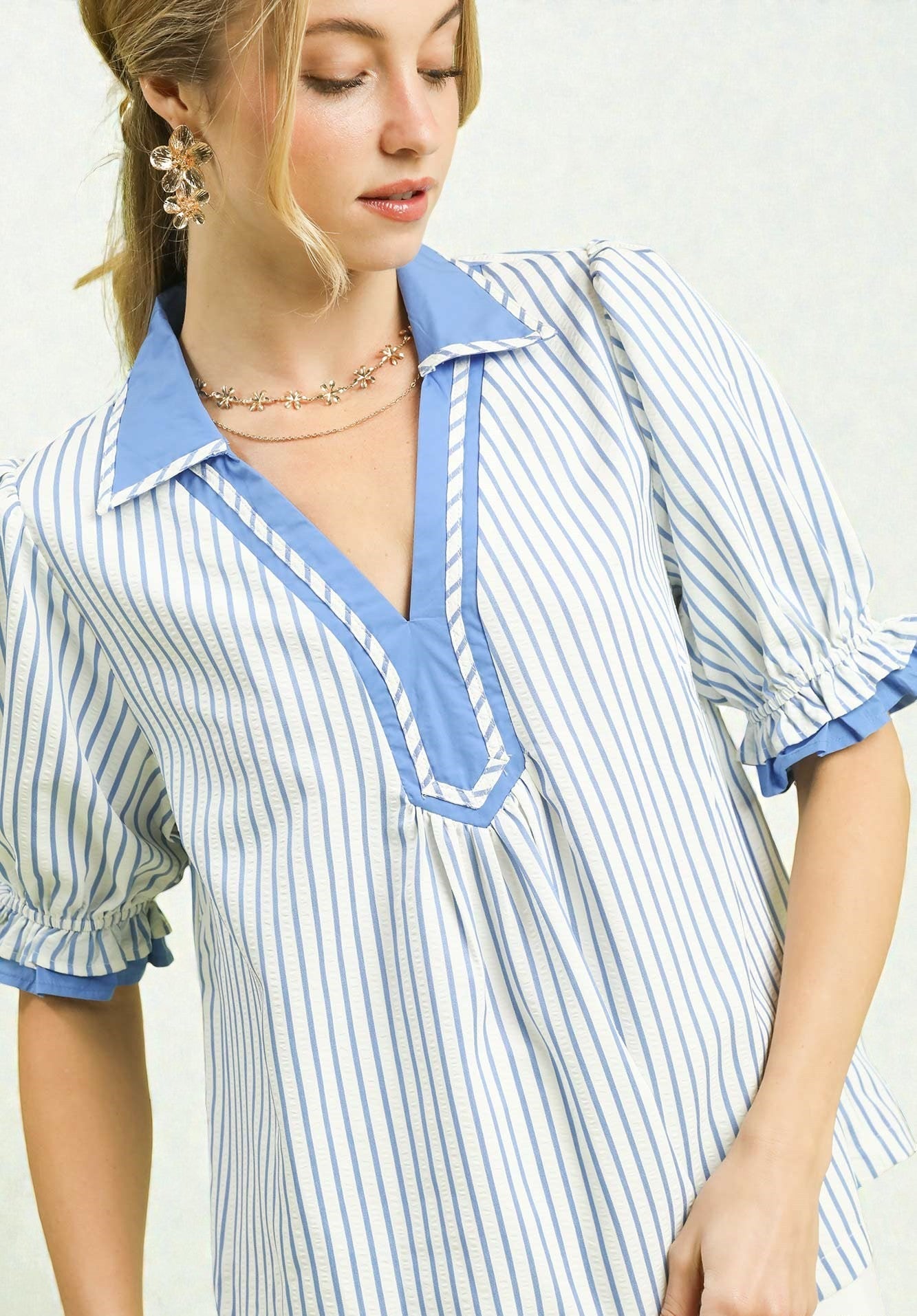 Woman wearing a blue and white striped dress with a plain background