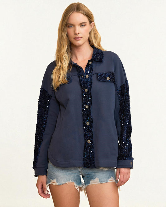 Woman wearing a navy blue shirt with sequin details on a white background