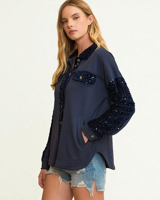 Woman wearing a navy blue sequin jacket on a white background
