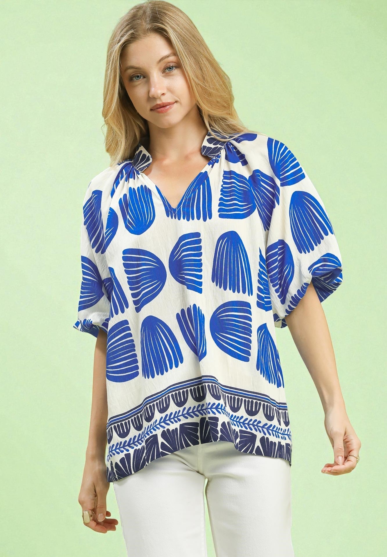 Woman wearing a blue and white patterned top on a light green background