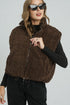Woman wearing a brown fleece vest against a plain background