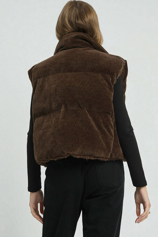 Brown puffer vest worn by a person on a white background