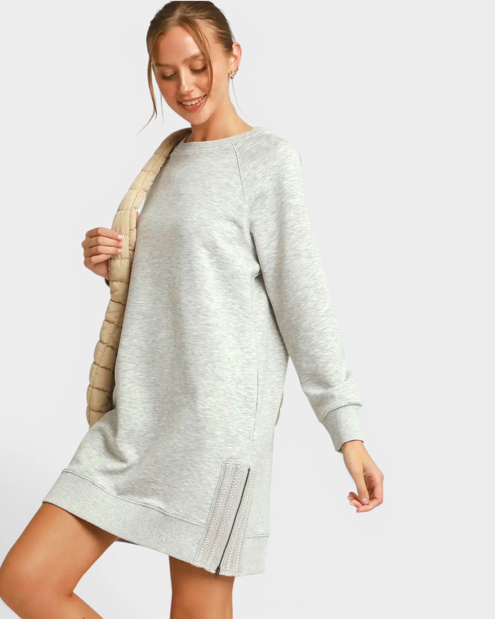 Woman wearing a gray sweatshirt dress on a light gray background