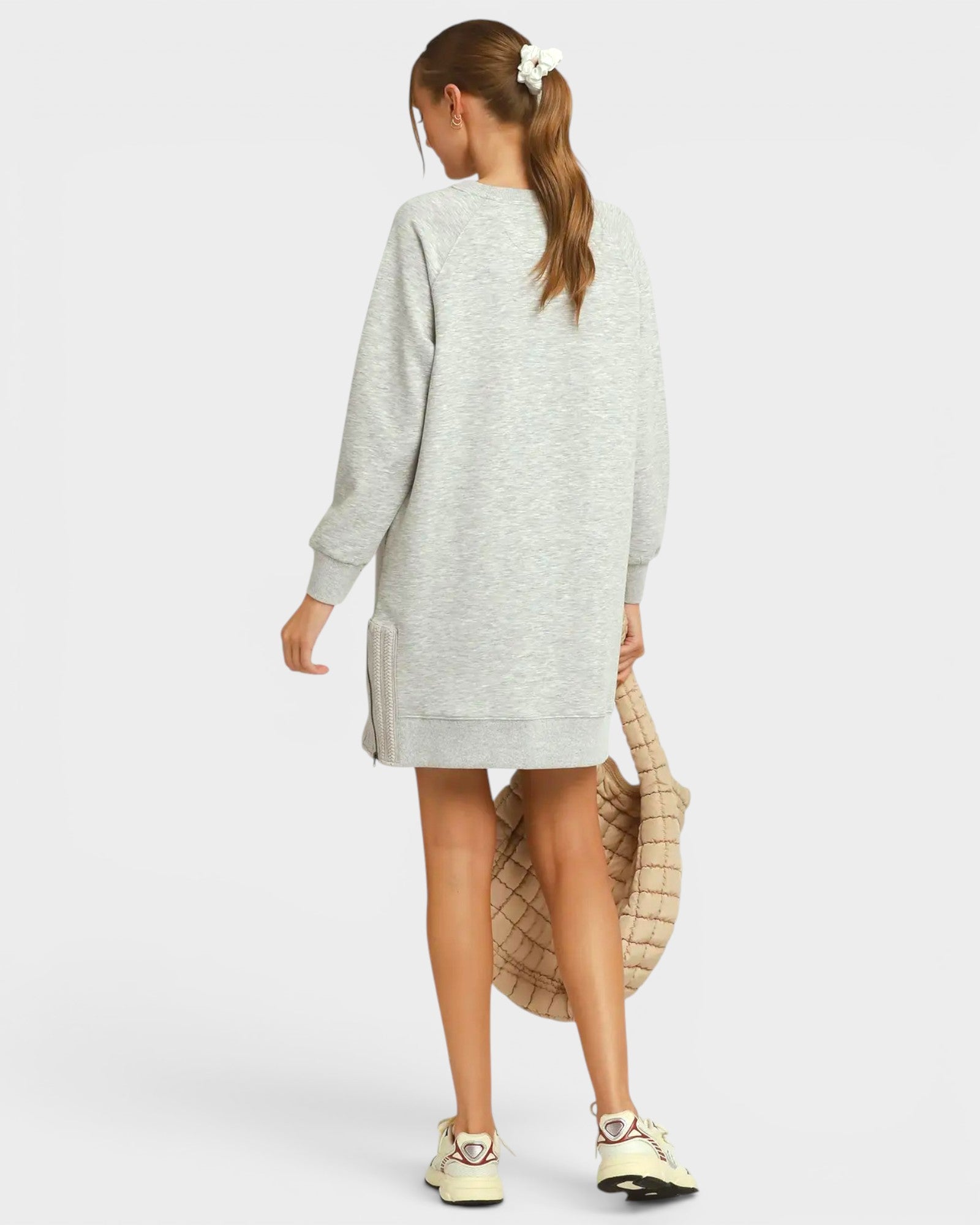 Person wearing a gray sweater dress on a white background
