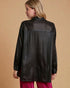 Woman wearing a black leather jacket on a beige background