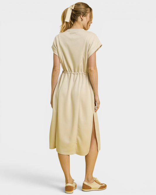 Woman wearing a beige dress on a white background