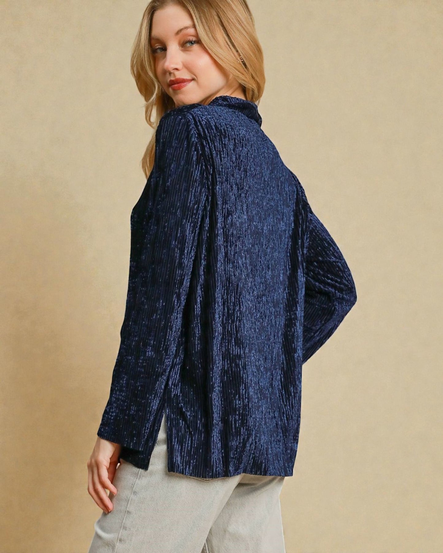 Woman wearing a blue textured shirt against a beige background