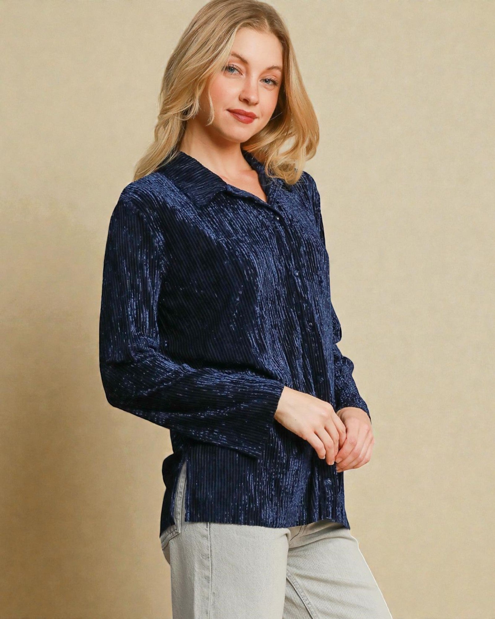 Woman wearing a blue textured shirt against a beige background