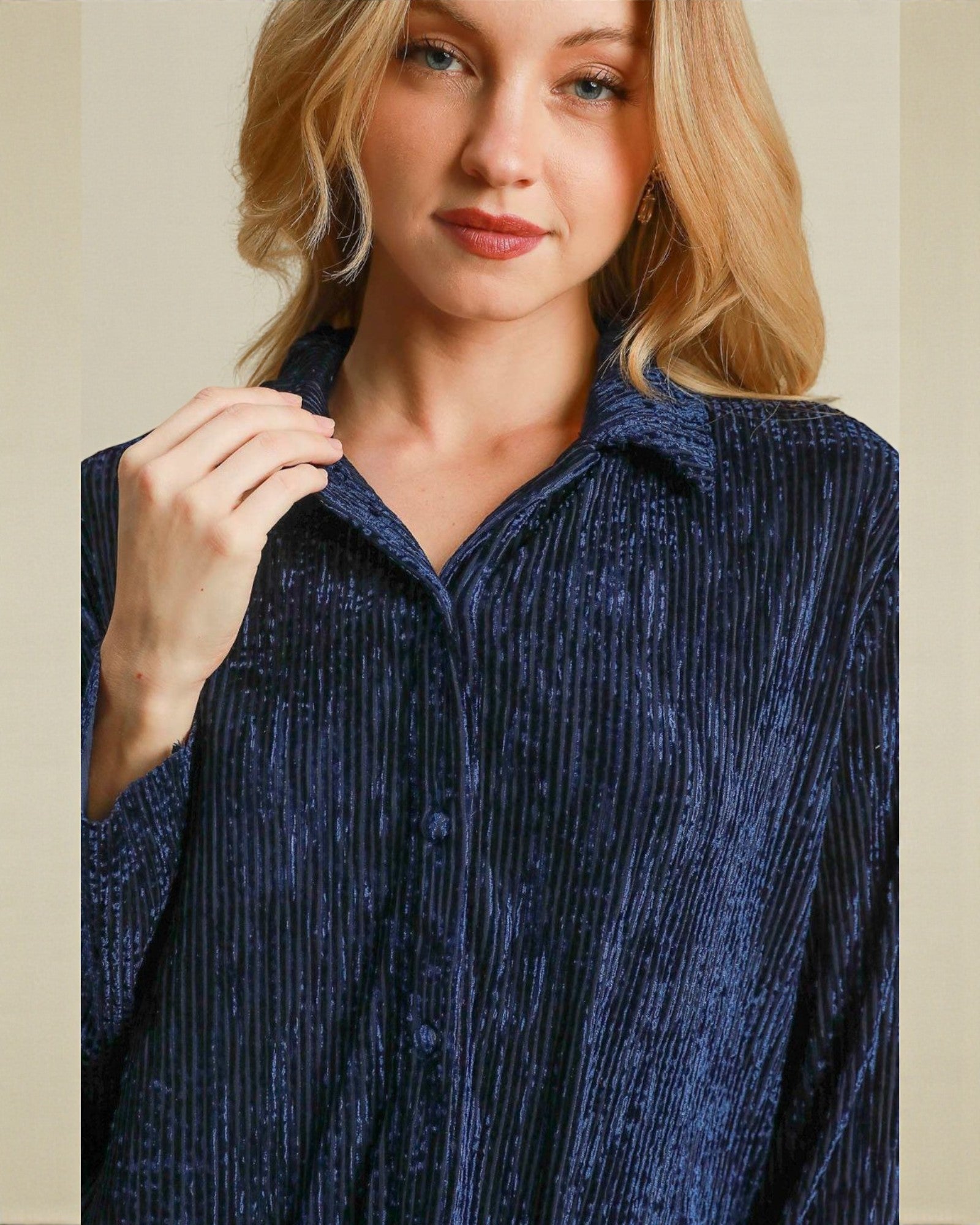 Woman wearing a blue textured shirt against a beige background