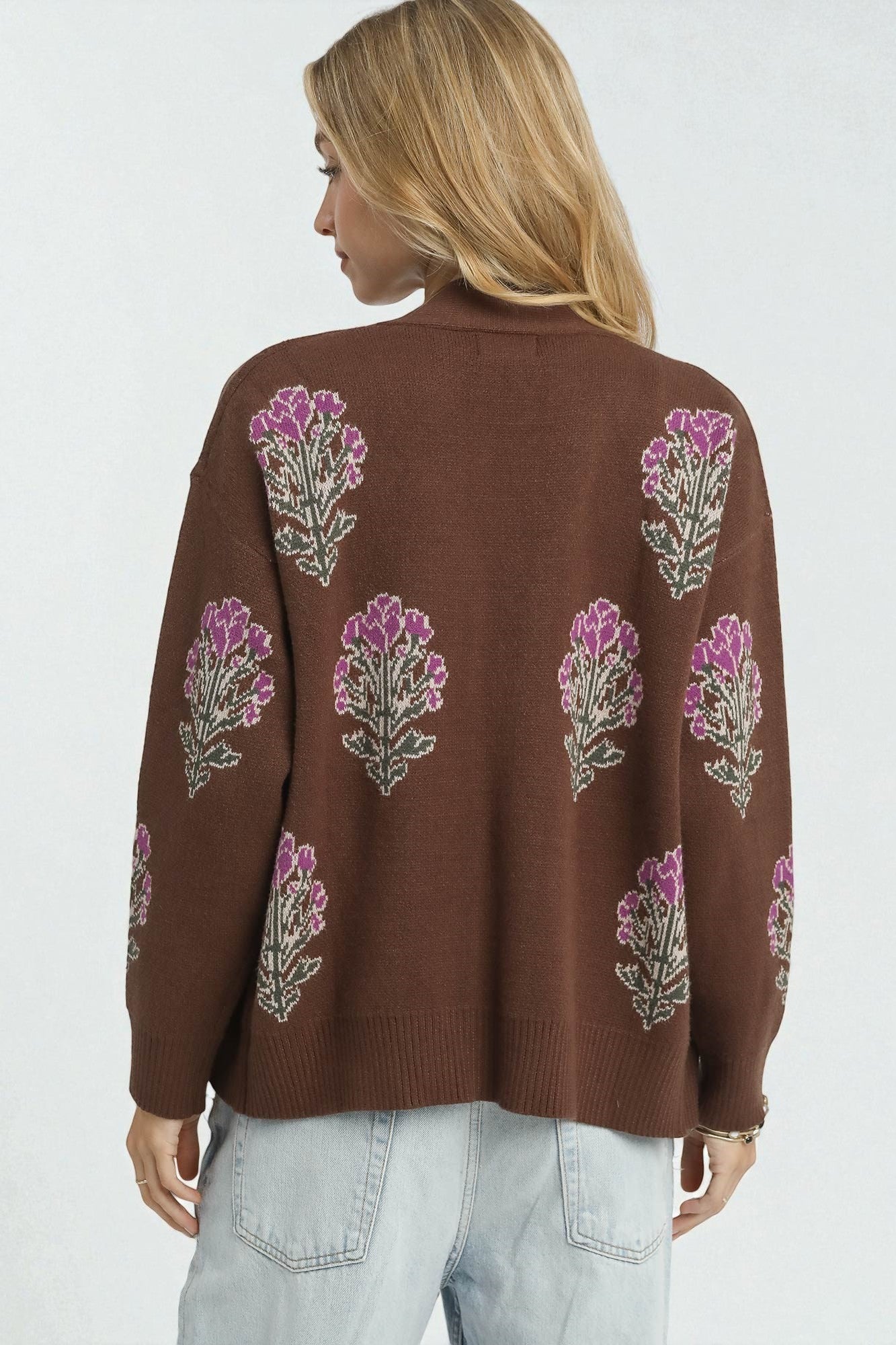 Brown sweater with floral patterns on a plain background