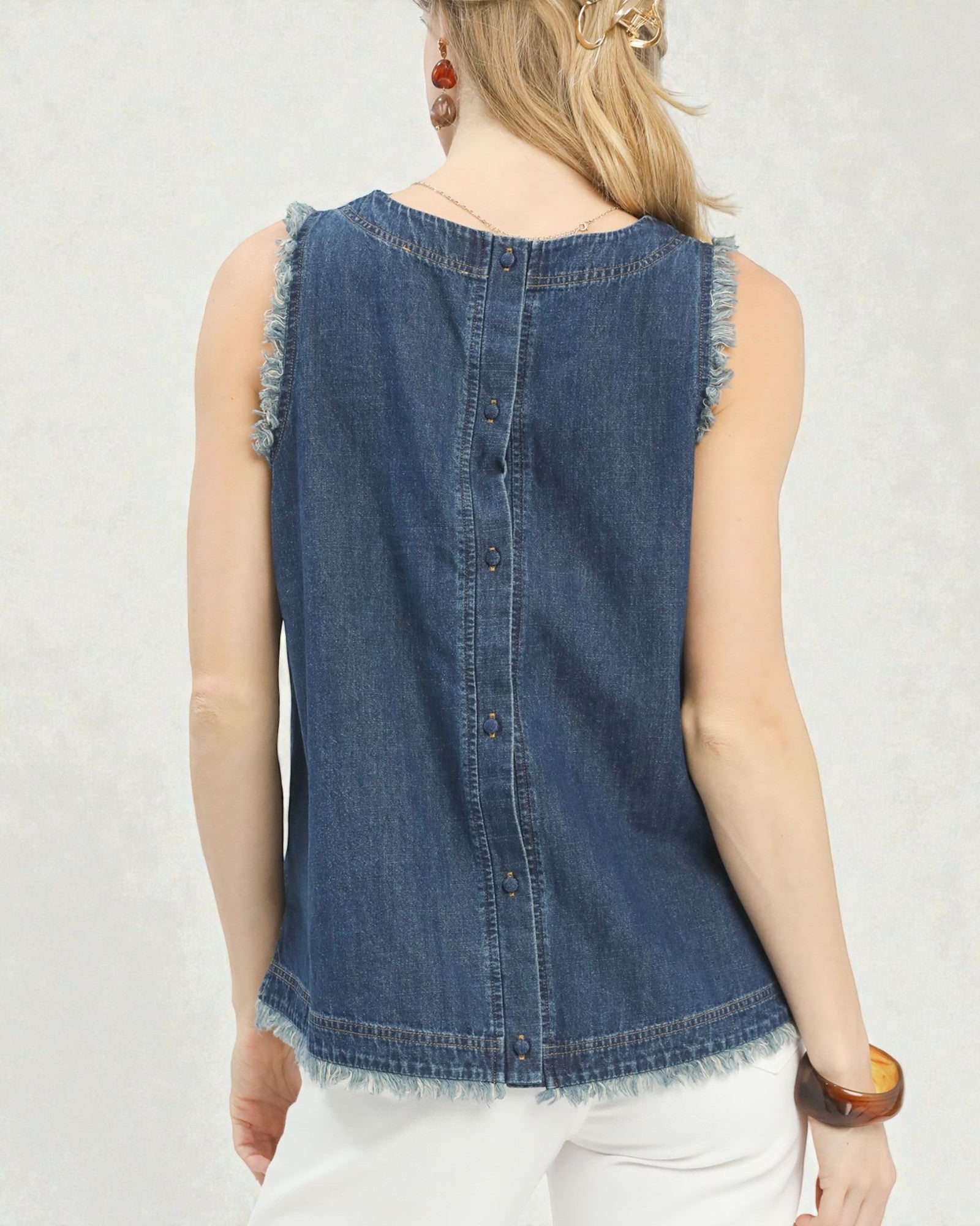 Denim sleeveless top worn by a person on a plain background