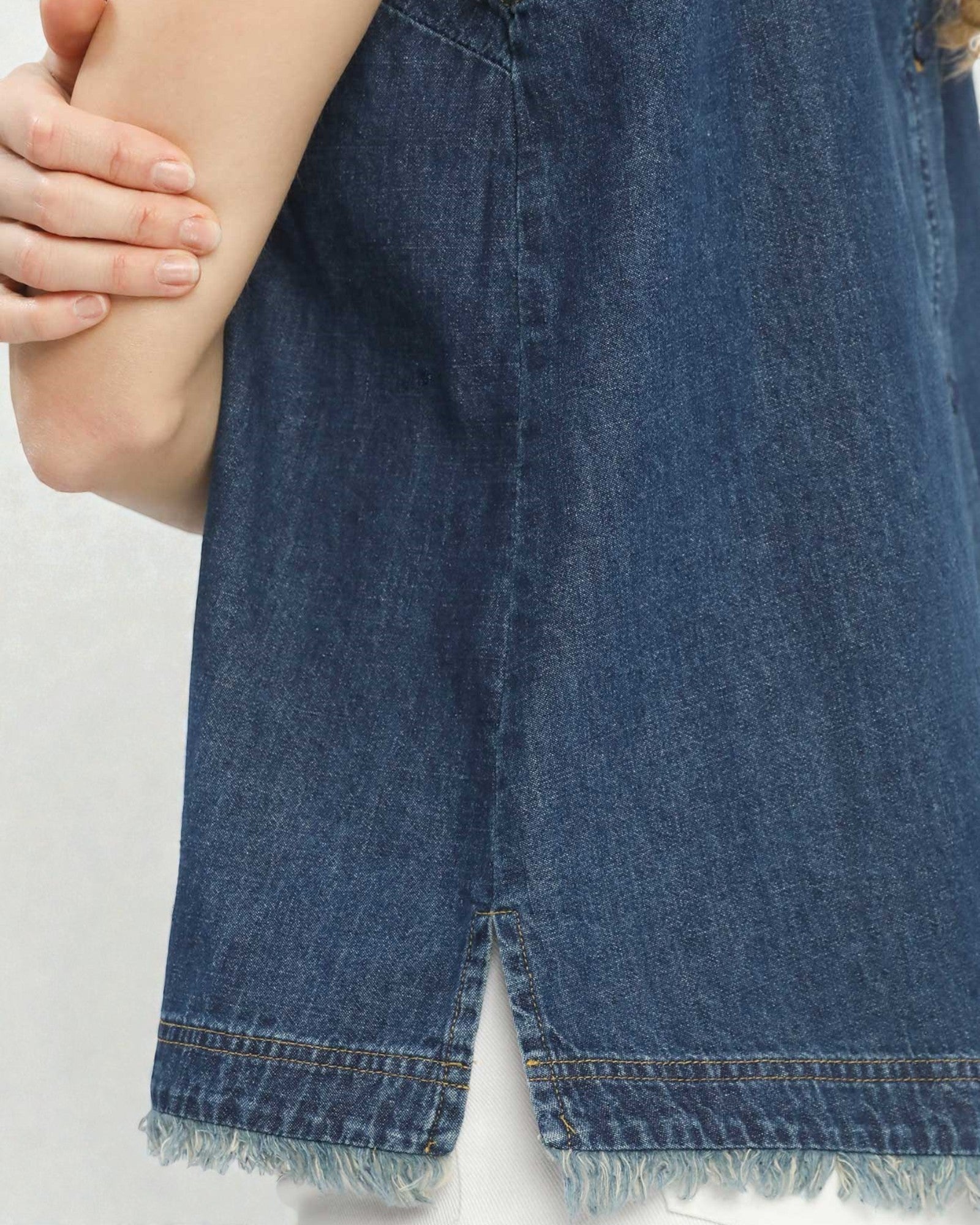 Close-up of a blue denim skirt with a white background