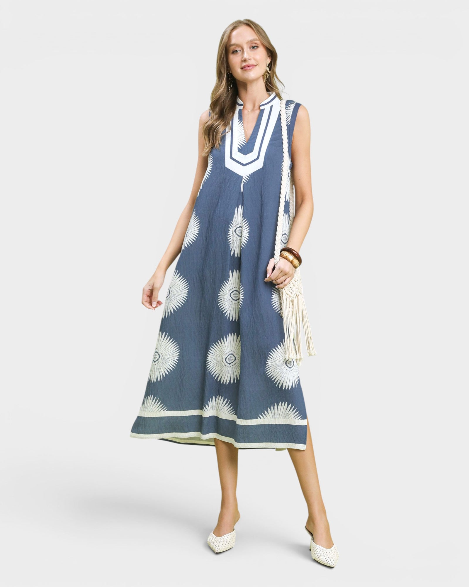 Woman wearing a blue dress with white patterns on a white background