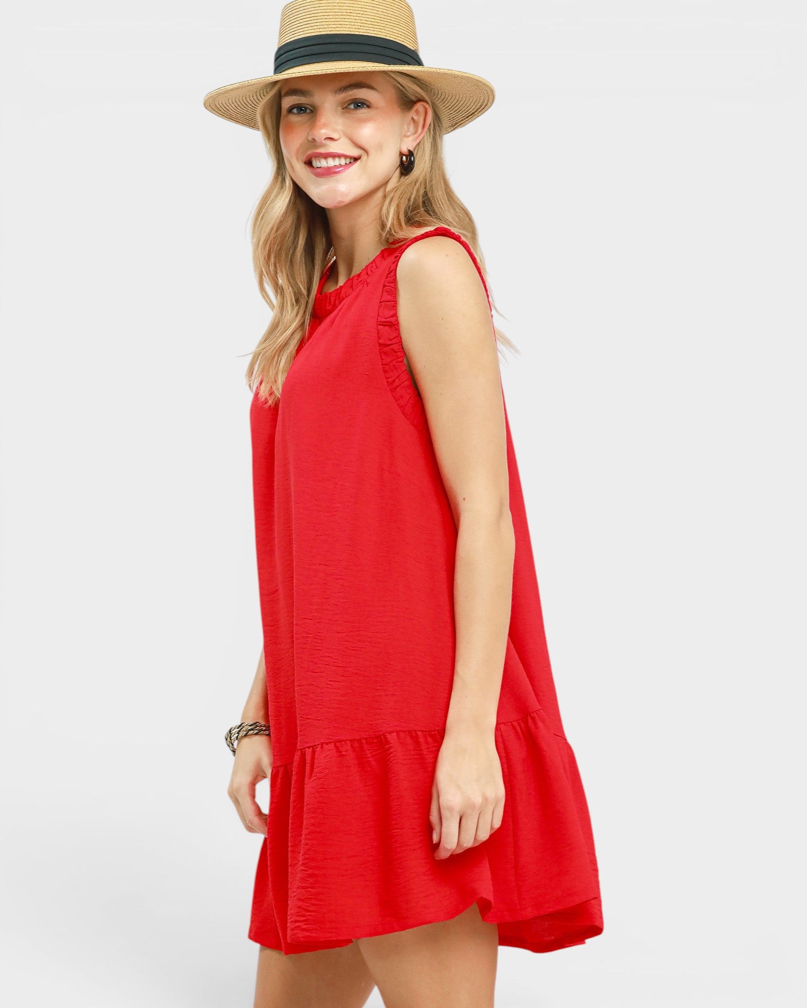 Woman wearing a red dress and straw hat on a white background