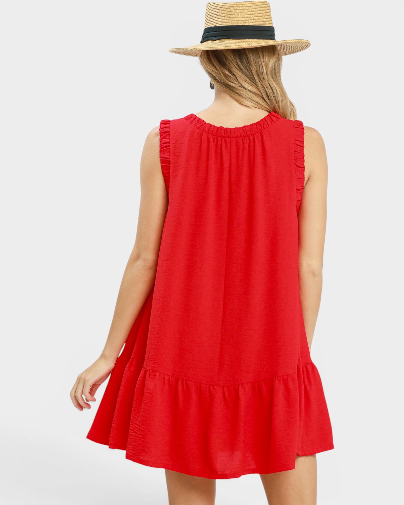 Woman wearing a red dress and straw hat on a white background