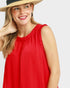 Woman wearing a red sleeveless dress and straw hat on a white background