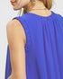 Blue sleeveless top worn by a person on a plain background