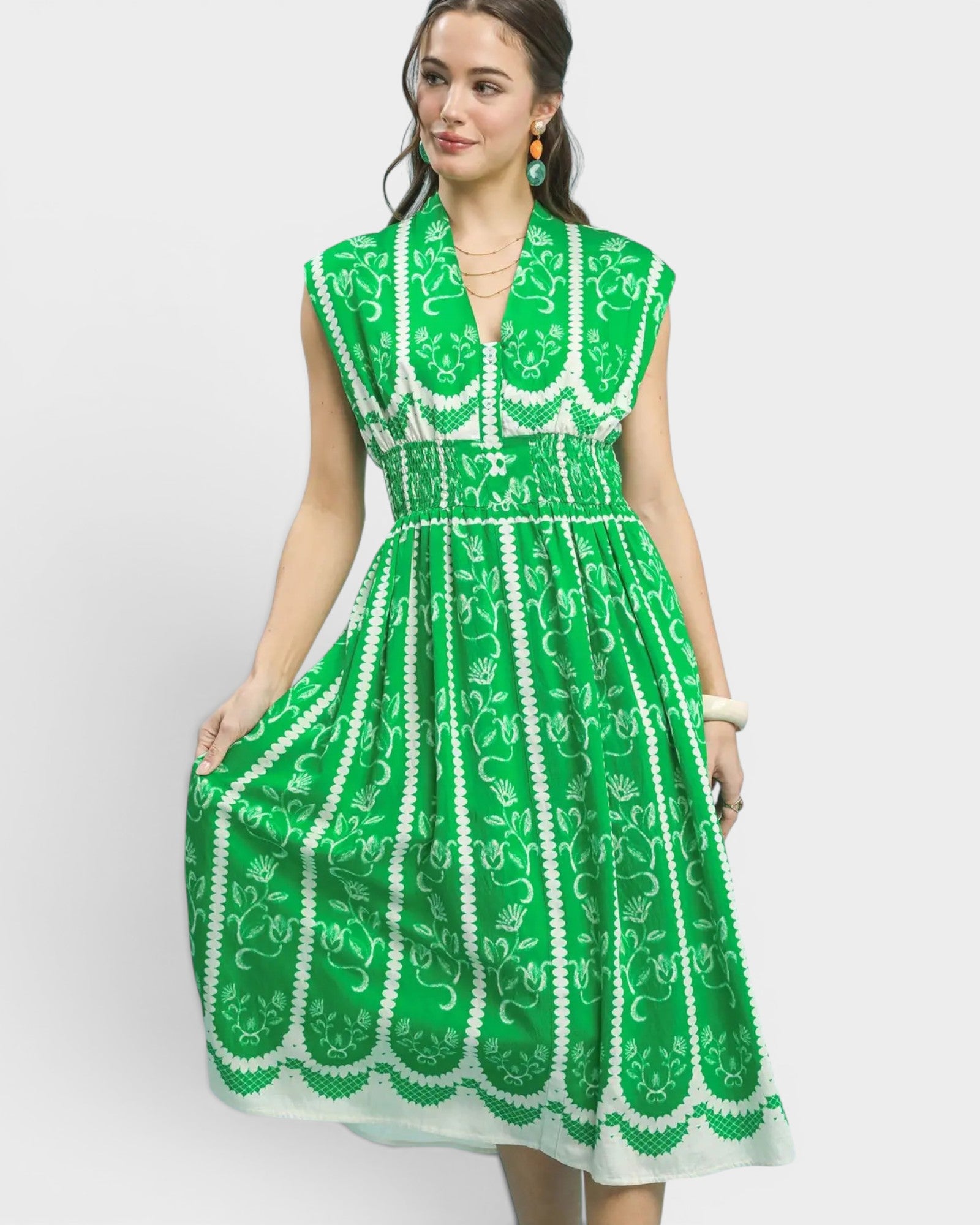Woman wearing a green and white patterned dress on a white background