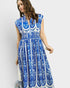 Woman wearing a blue and white patterned dress on a plain background
