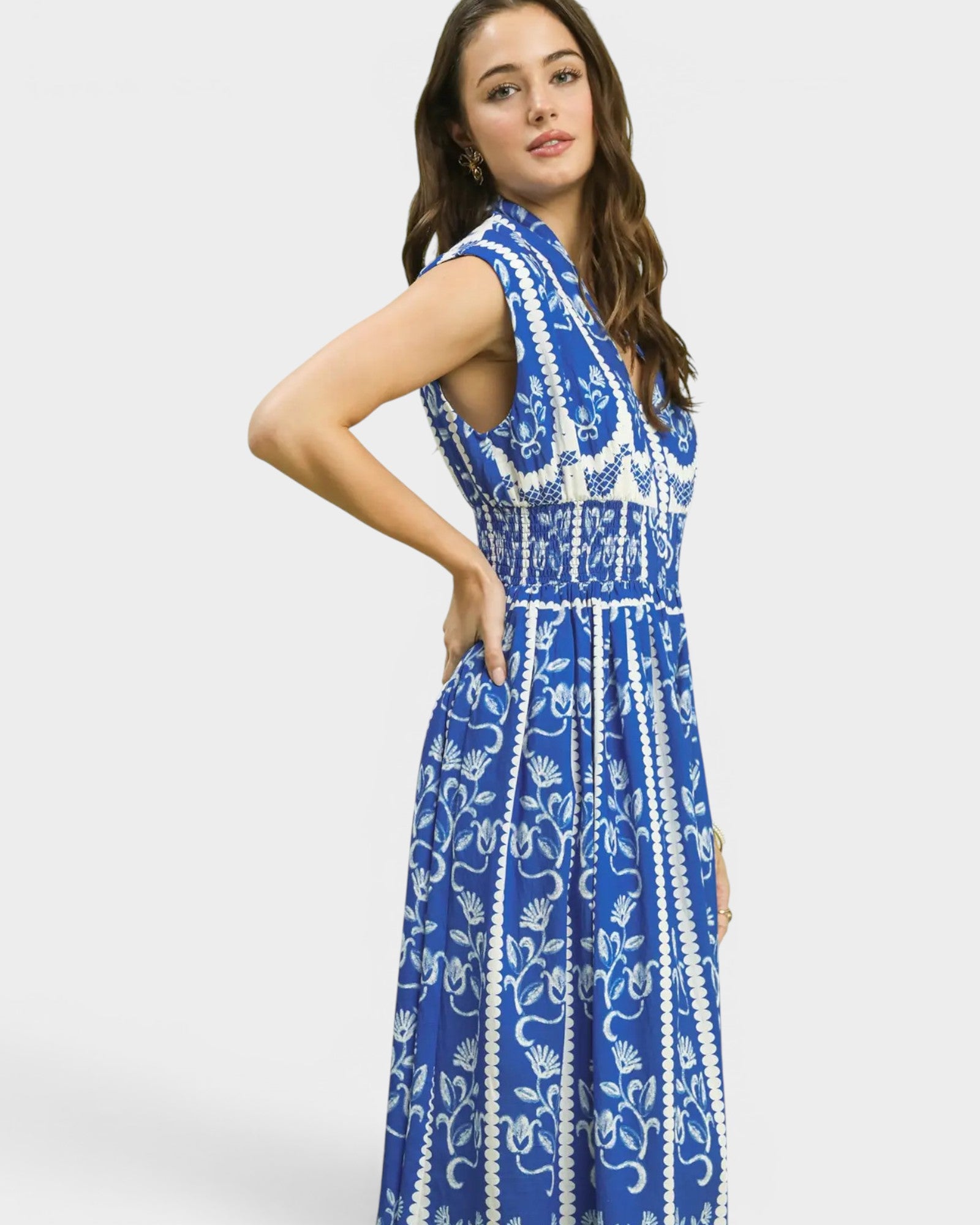 Woman wearing a blue and white patterned dress on a plain background