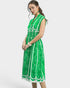 Woman wearing a green dress with white patterns on a white background