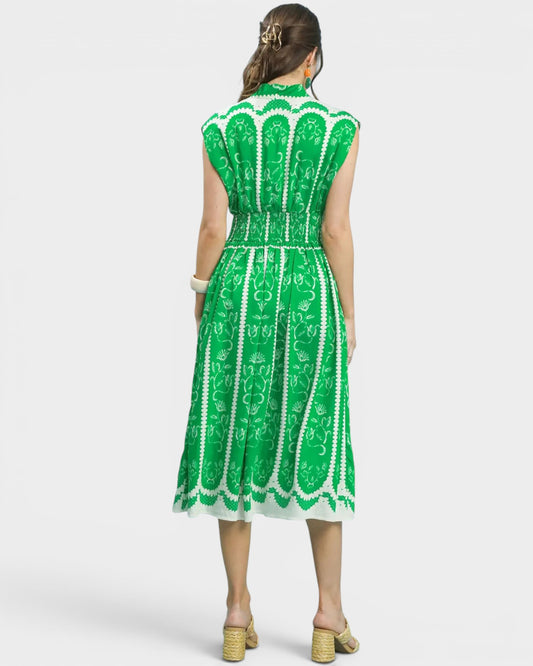 Green and white patterned dress on a model against a white background