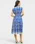 Woman wearing a blue and white patterned dress on a light gray background