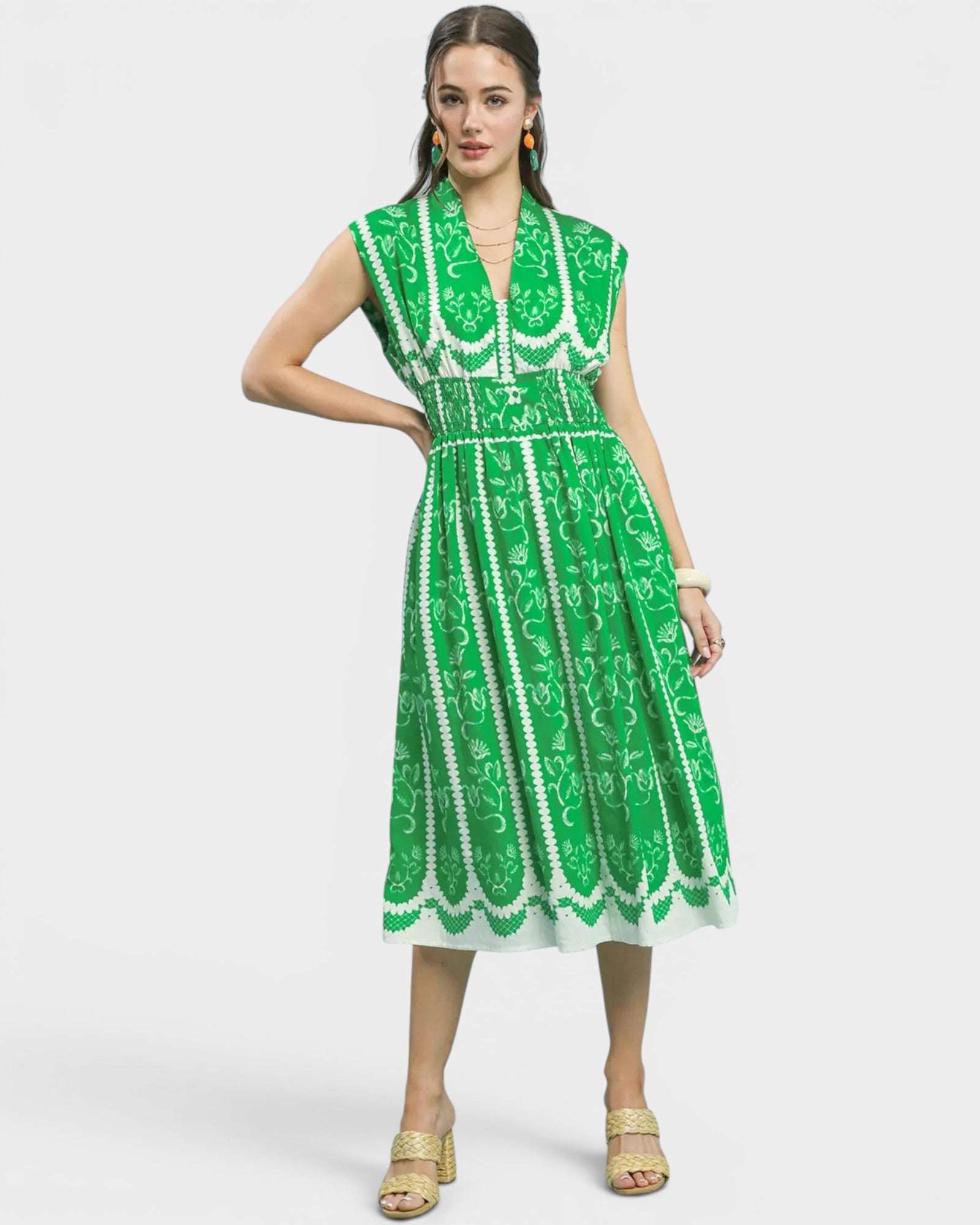 Woman wearing a green and white patterned dress on a white background