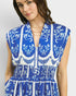 Woman wearing a blue and white patterned dress on a plain background