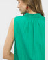 Green sleeveless top worn by a person on a white background