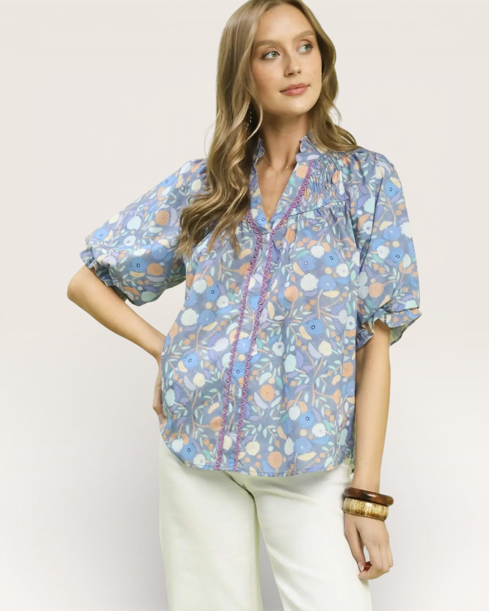 Woman wearing a blue floral blouse against a plain background