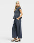 Woman wearing a blue top and wide-leg pants on a white background