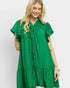 Woman wearing a green dress with ruffled details on a white background