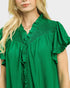 Green dress with ruffled details worn by a person on a white background