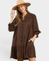 Woman wearing a brown dress and beige hat on a white background