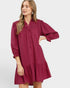 Woman wearing a burgundy dress with long sleeves on a white background