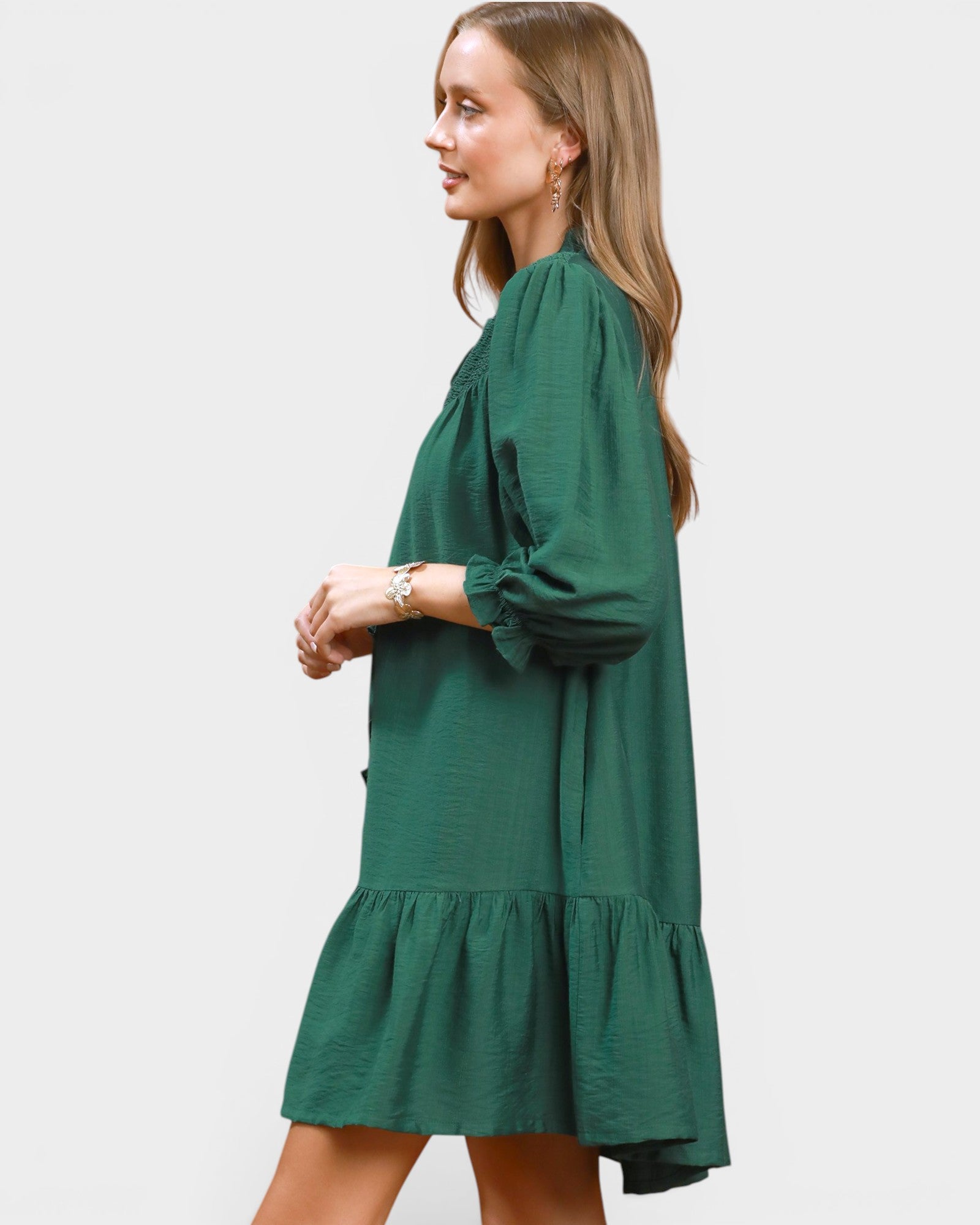 Woman wearing a green dress on a plain background