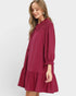 Woman wearing a burgundy dress with lace details on a white background