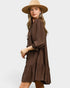 Woman wearing a brown dress and beige hat on a white background