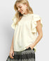 Woman wearing a light-colored blouse with ruffled sleeves on a plain background