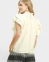 Woman wearing a light yellow blouse with ruffled sleeves on a white background