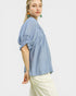 Woman wearing a light blue blouse with ruffled sleeves on a white background