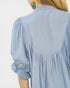 Light blue blouse with ruffled sleeves on a plain background